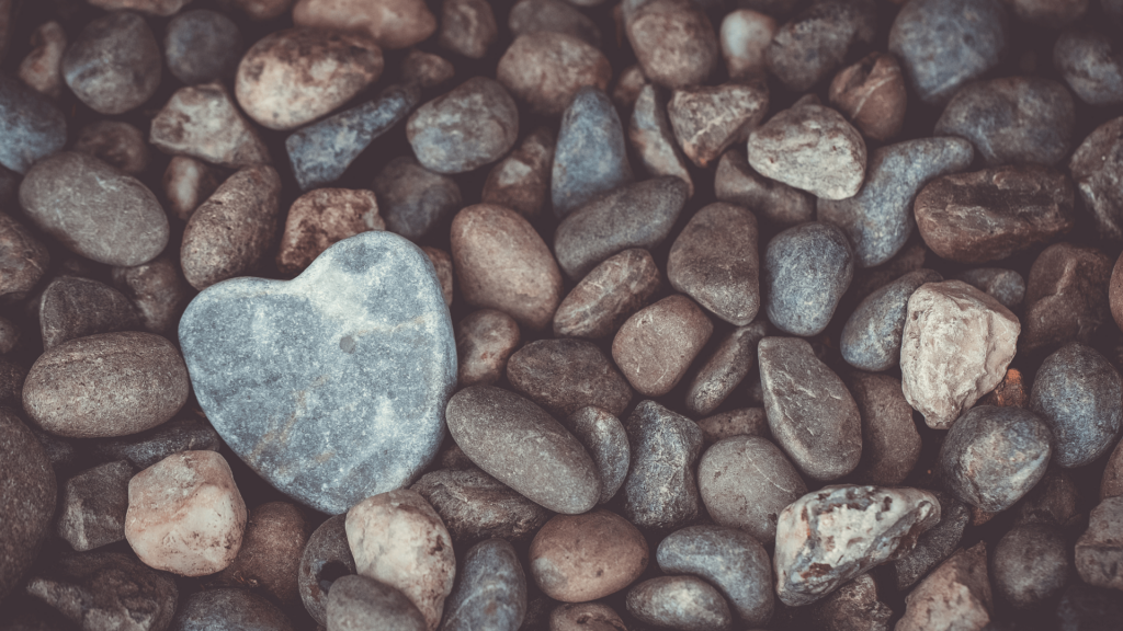 A collection of stones wit one heart-shaped gray stone towards the bottom left