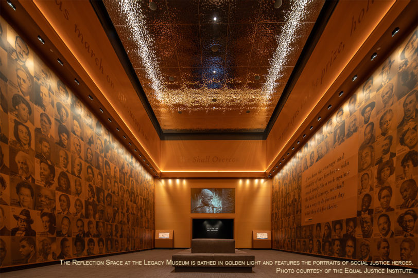 Interior of a museum hall with golden lighting, featuring walls adorned with historical portraits and quotes.