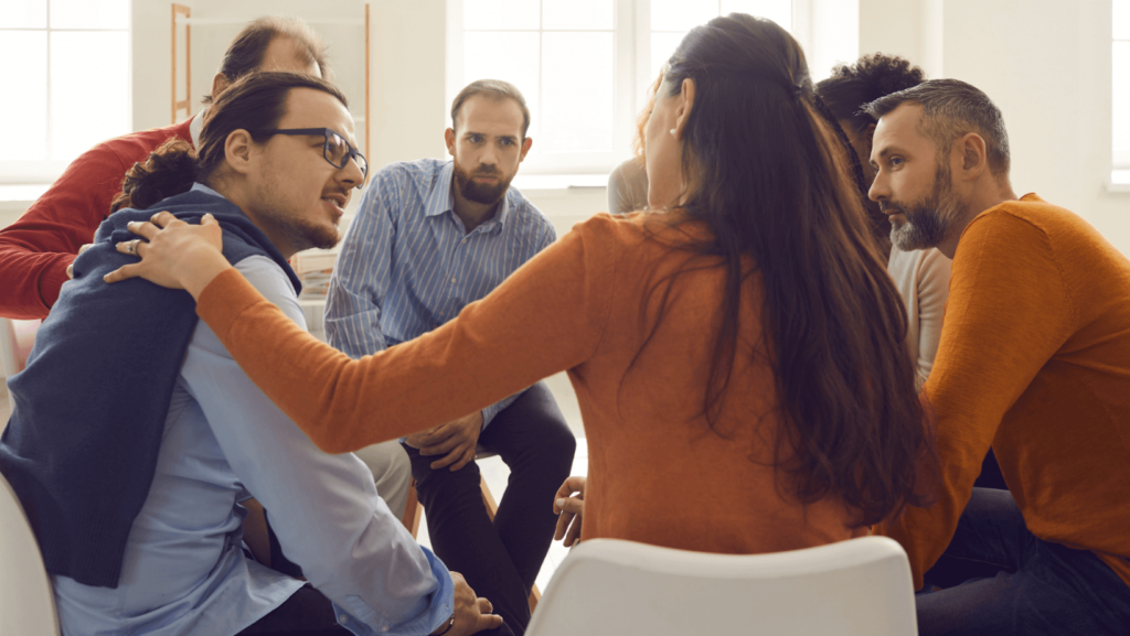 A group of multicultural young adults sitting in a circle talking