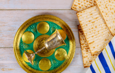Passover Seder plate with a silver goblet and matzah on a wooden table.