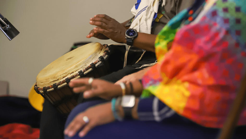 Close-up of people in colorful clothes playing the drums