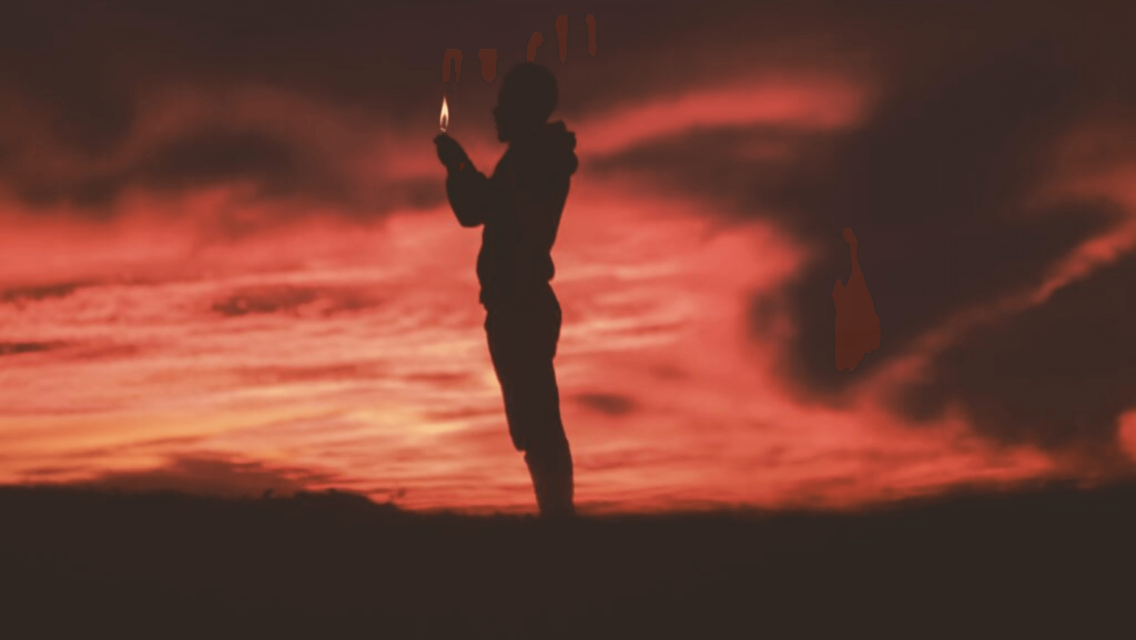 A figure holding a small light silhouetted against a red sky