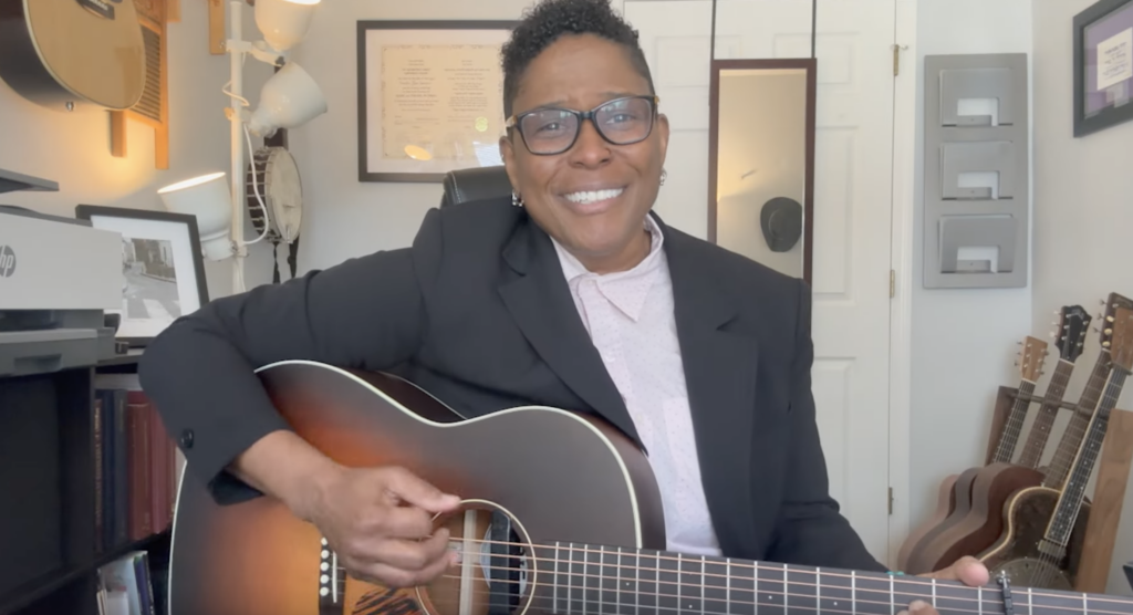 Rabbi Sandra Lawson playing an acoustic guitar