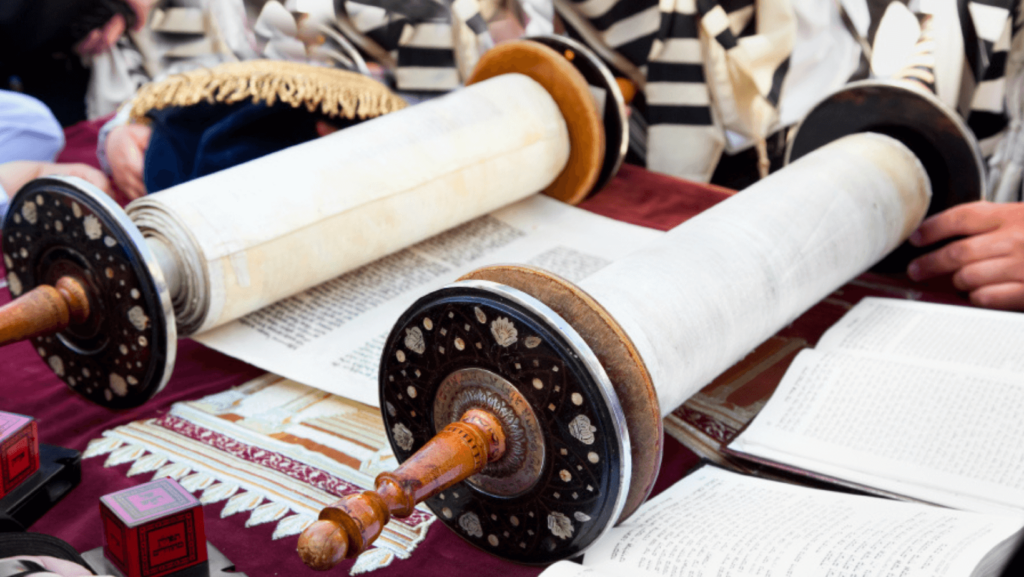 A Torah scroll open on a wooden desk