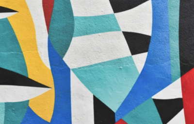 Colorful abstract mural with geometric shapes in blue, red, yellow, black, and white.
