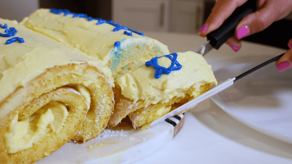 Milk and Honey roll cake being cut unto slices