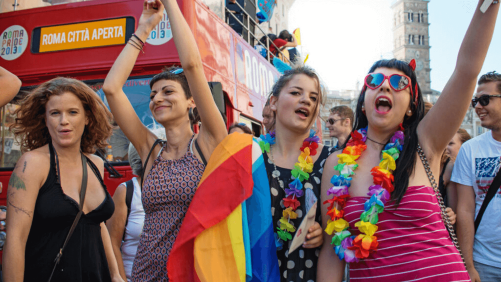 People celebrating Pride with rainbow flags and brightly colored outfits