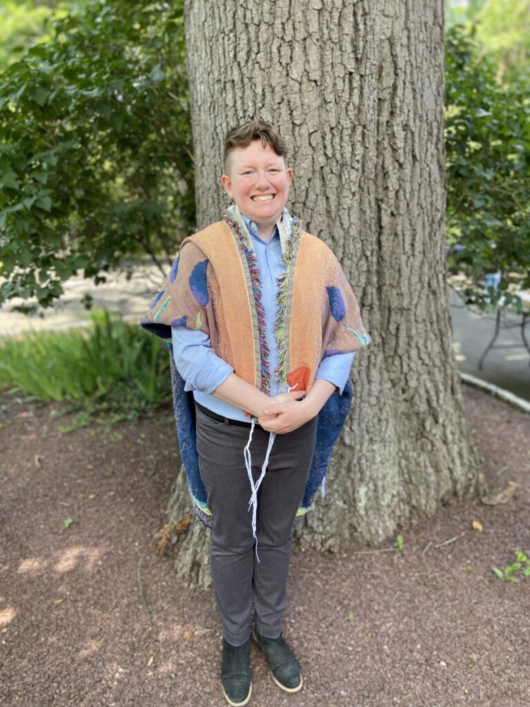 A near full body shot of Rabbi Lily Solochek wearing a tallis.