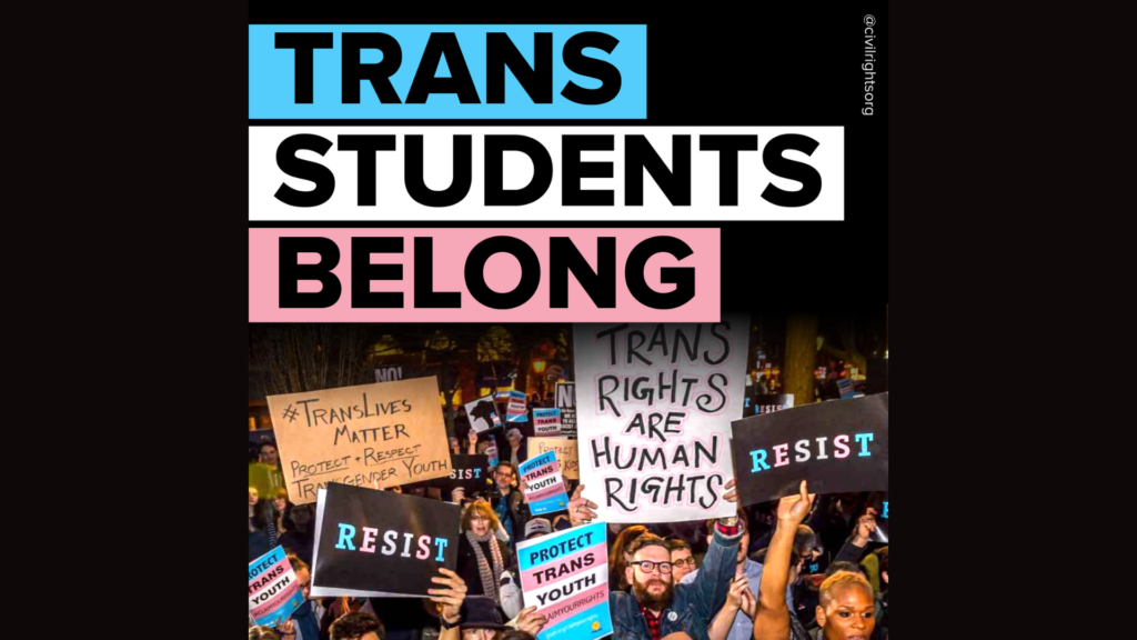People holding signs supporting trans student rights at a protest.