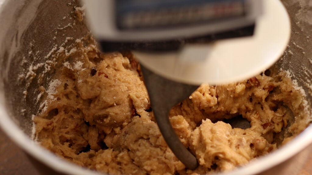 Close-up of cookie dough being mixed in a stand mixer.