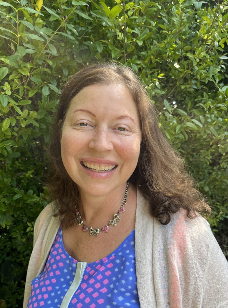 Gabrielle Kaplan-Mayer smiles in front of a tree.