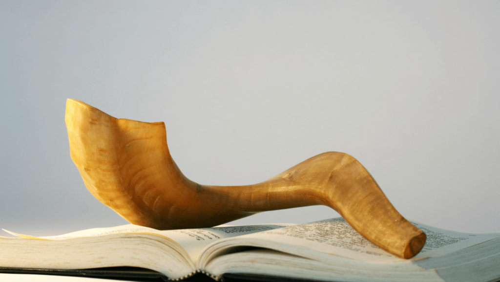 A shofar sitting on top of an open prayer book