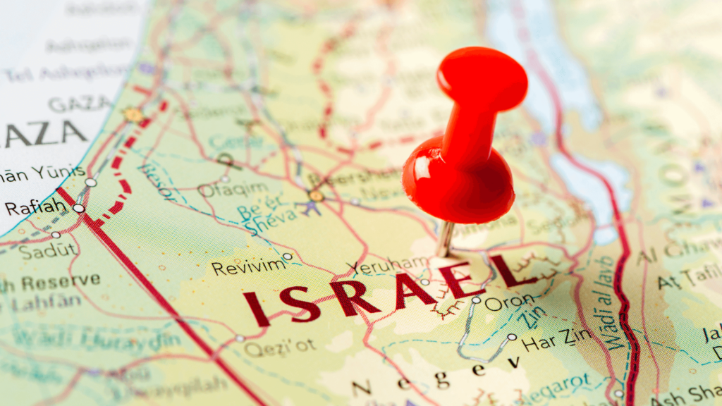 A map of Israel with a red pushpin stuck into it