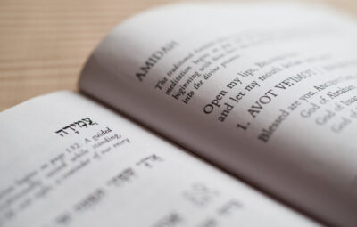 Open prayer book with Hebrew and English text on its pages.