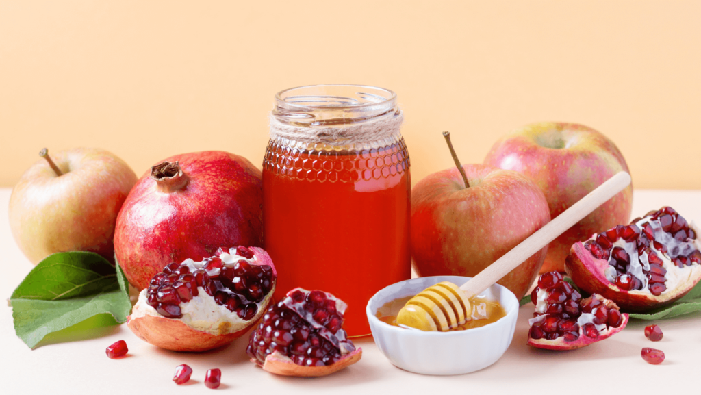 A Rosh Hashana table set up with apples, honey, and pomegranate