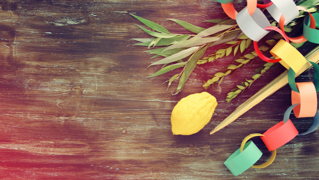 A lemon, paper chains, and greenery on a wooden surface.