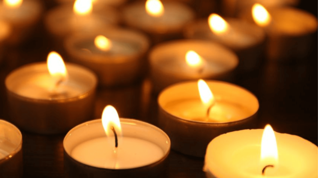 A group of lit votive candles