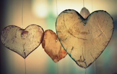 Three heart-shaped wood slices hanging on strings, creating a rustic and romantic atmosphere.