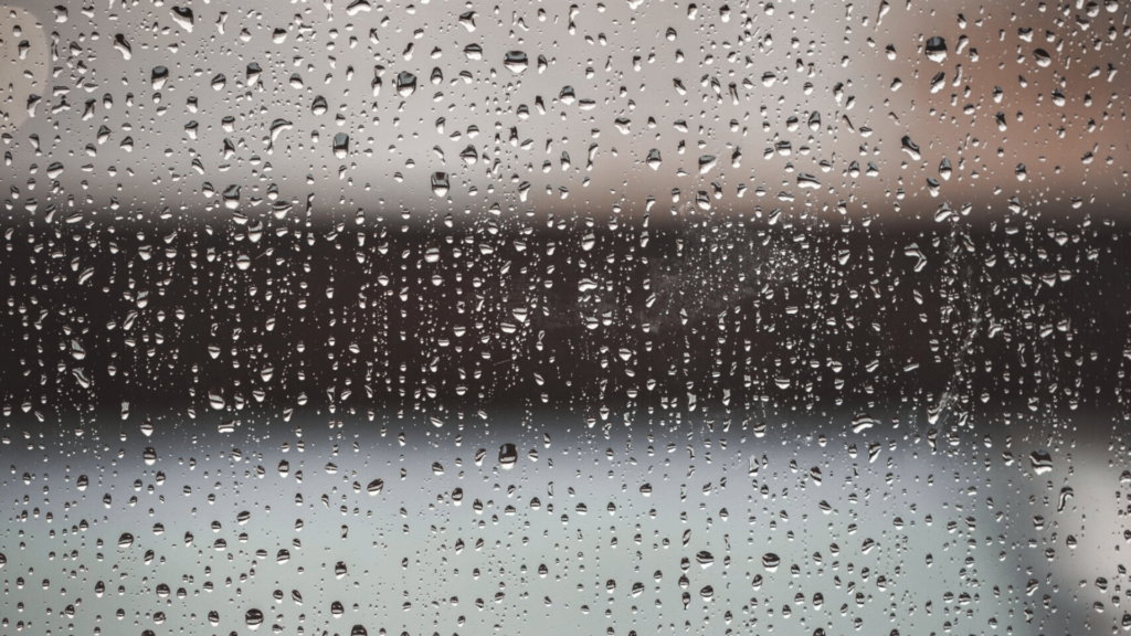Raindrops on a window against a gray background