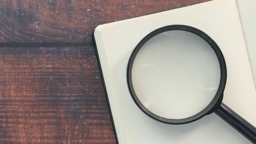 A magnifying glass lying over a sheet of paper