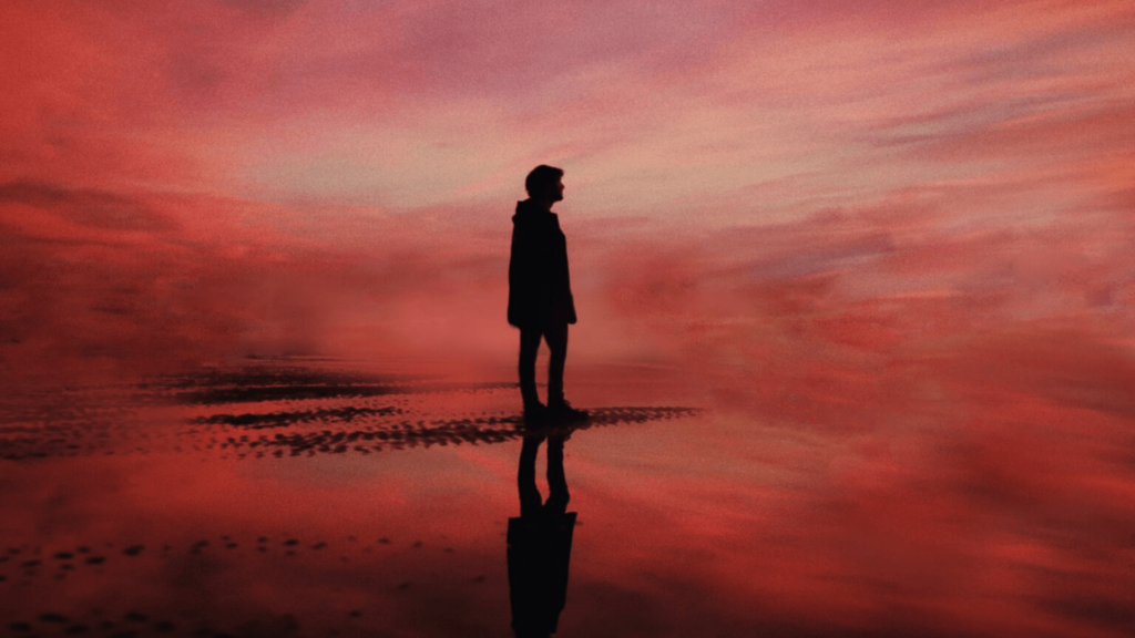 Person silhouetted against a cloudy pink background