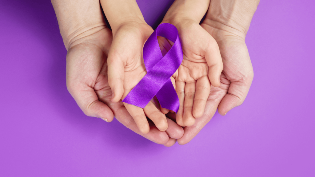 Child and adult hands holding a purple ribbon against a purple background