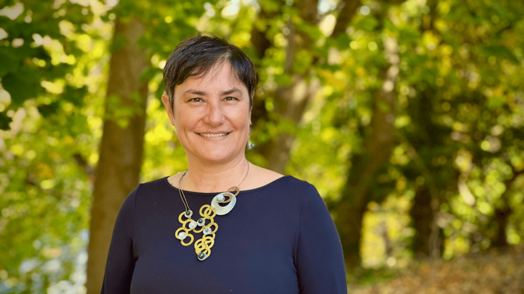 Rabbi Deborah Waxman outside with trees behind her