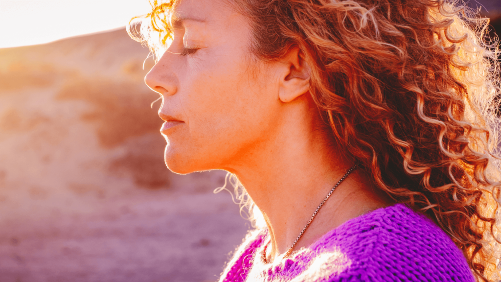 Woman with wavy hair outside during golden hour