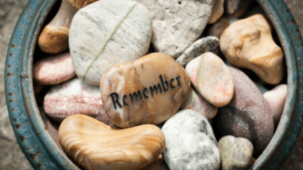 Small stones in a bowl, one stone is inscribed with the word Remember