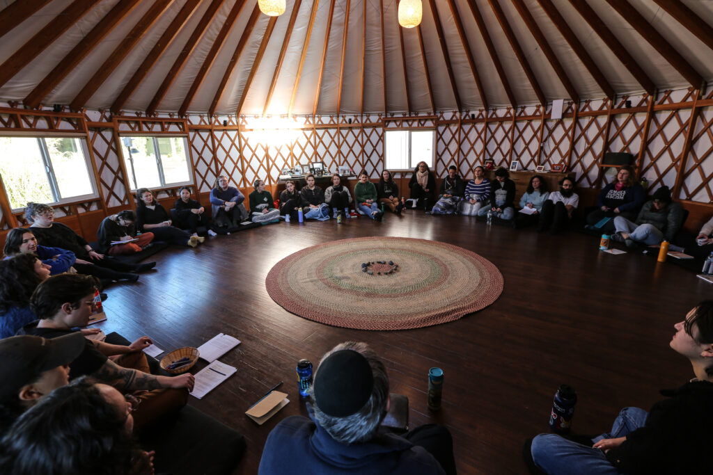 A group sits in a circle in a yurt structure. Participants at a recent grief retreat in California.