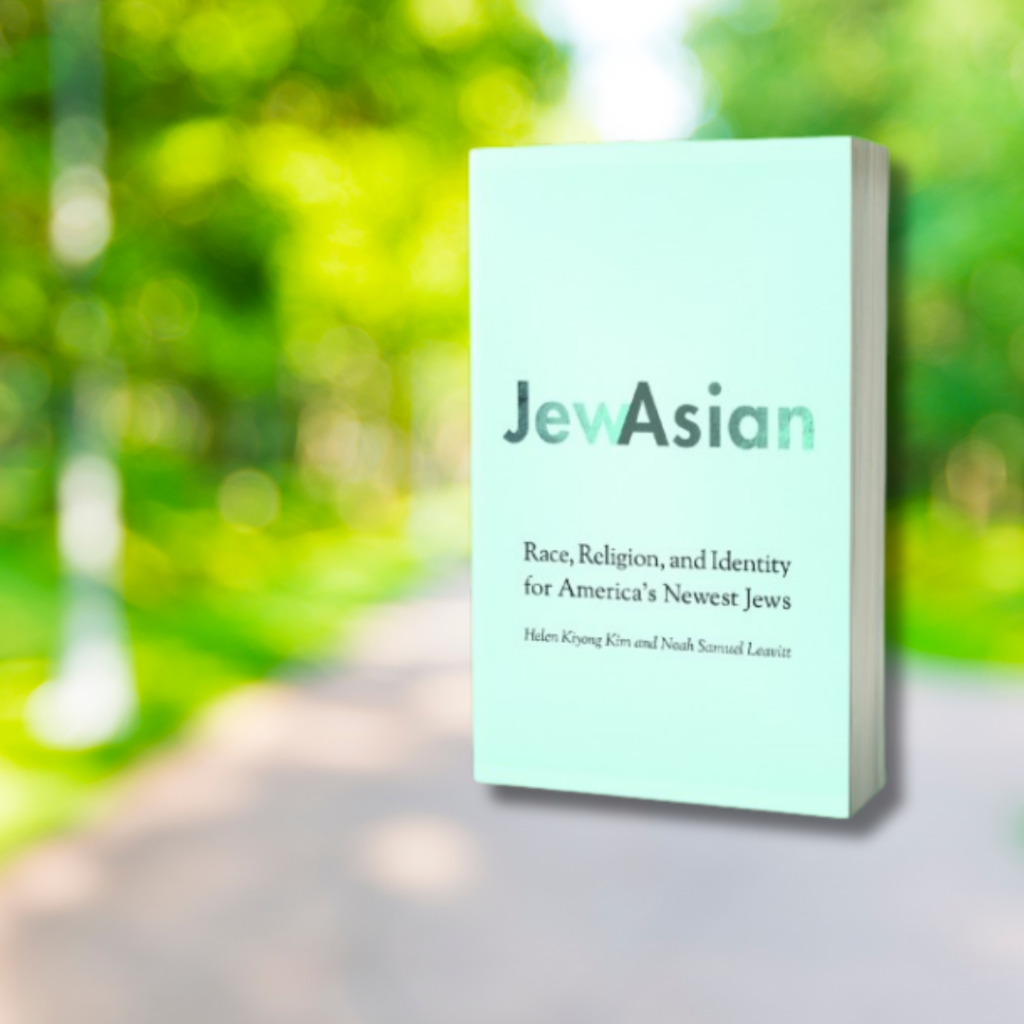 Book titled JewAsian with a blurred green park in the background.