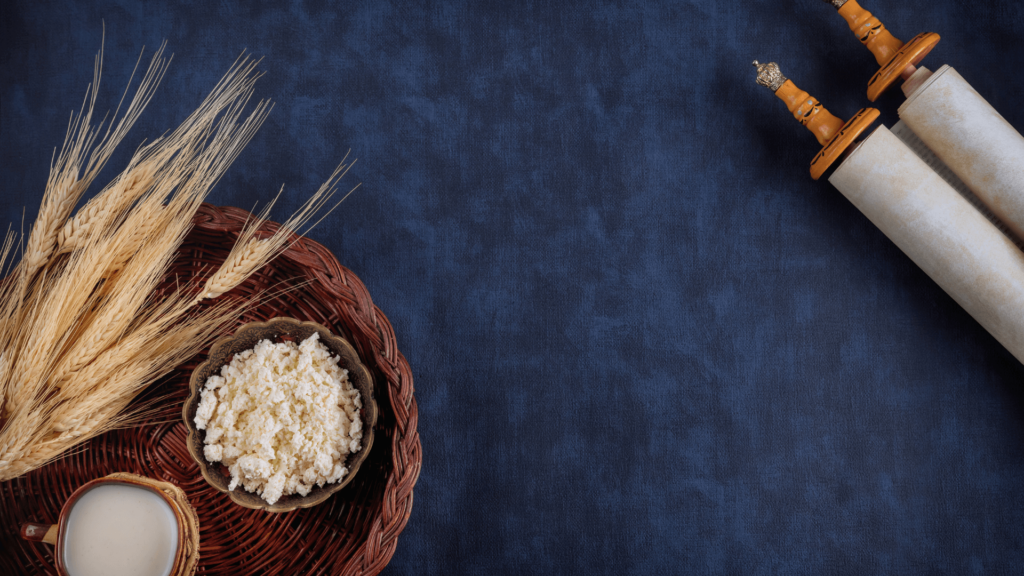 A Torah scroll and a bowl of wheat products on a blue tablecloth