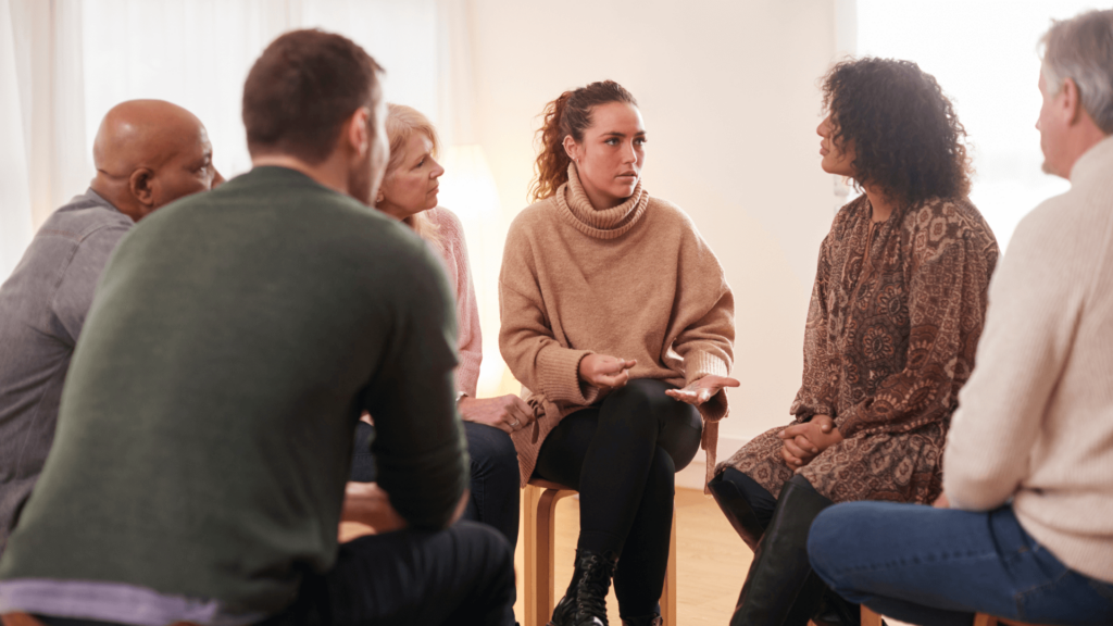 A multicultural group of adults sitting in a circle and talking