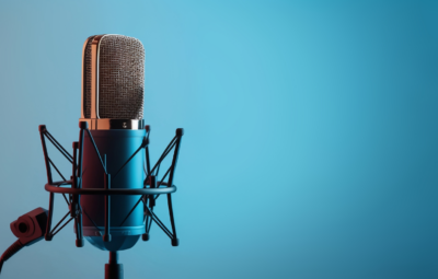 A vintage-style microphone on a stand against a blue gradient background.
