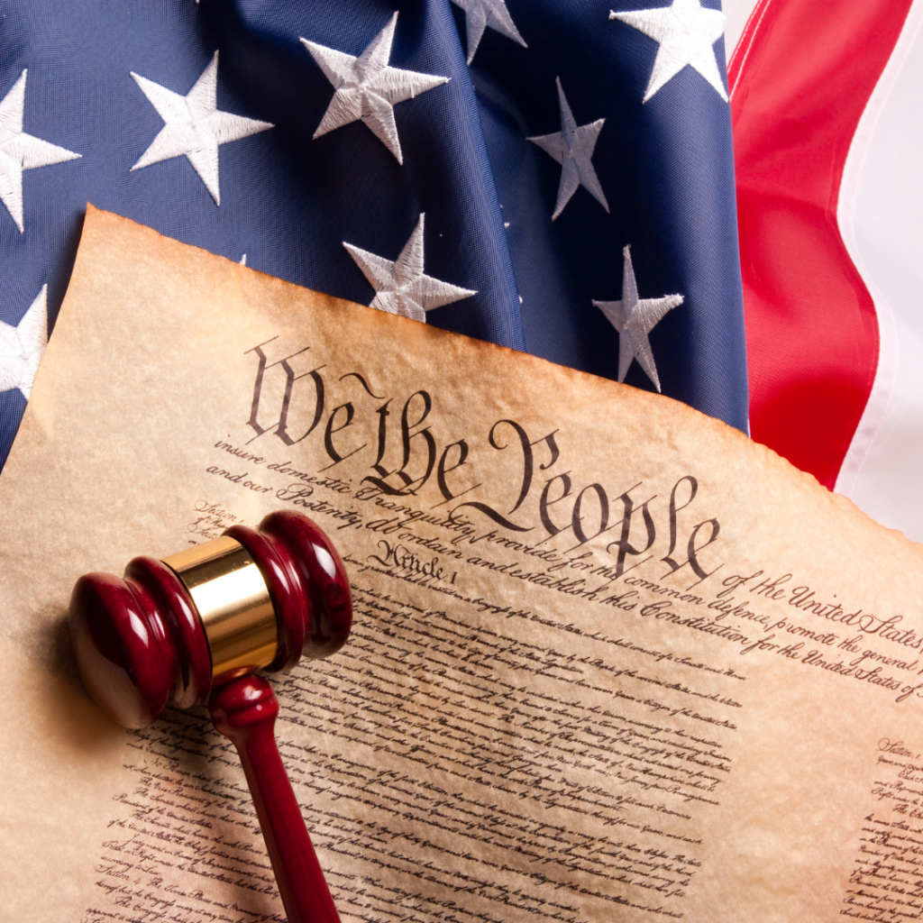 The U.S. Constitution and a gavel rest on the American flag.