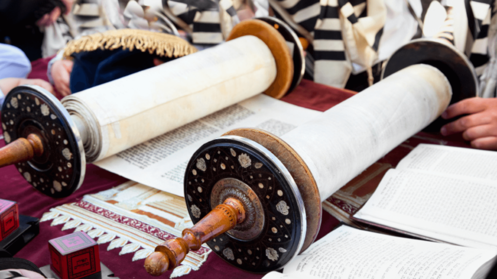 A person opening a Torah scroll