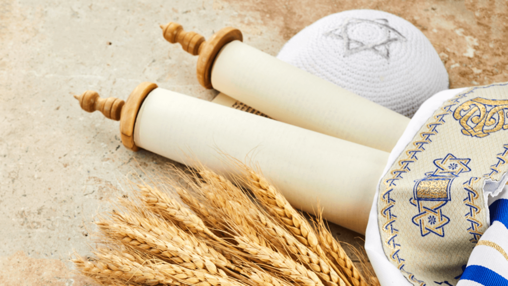 A Torah scroll surrounded by wheat and a yarmulke with a Jewish star pattern