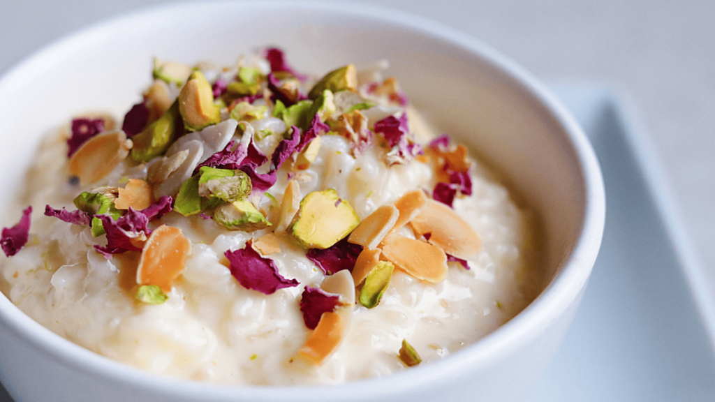 A cup of rice pudding with toppings including different types of nuts