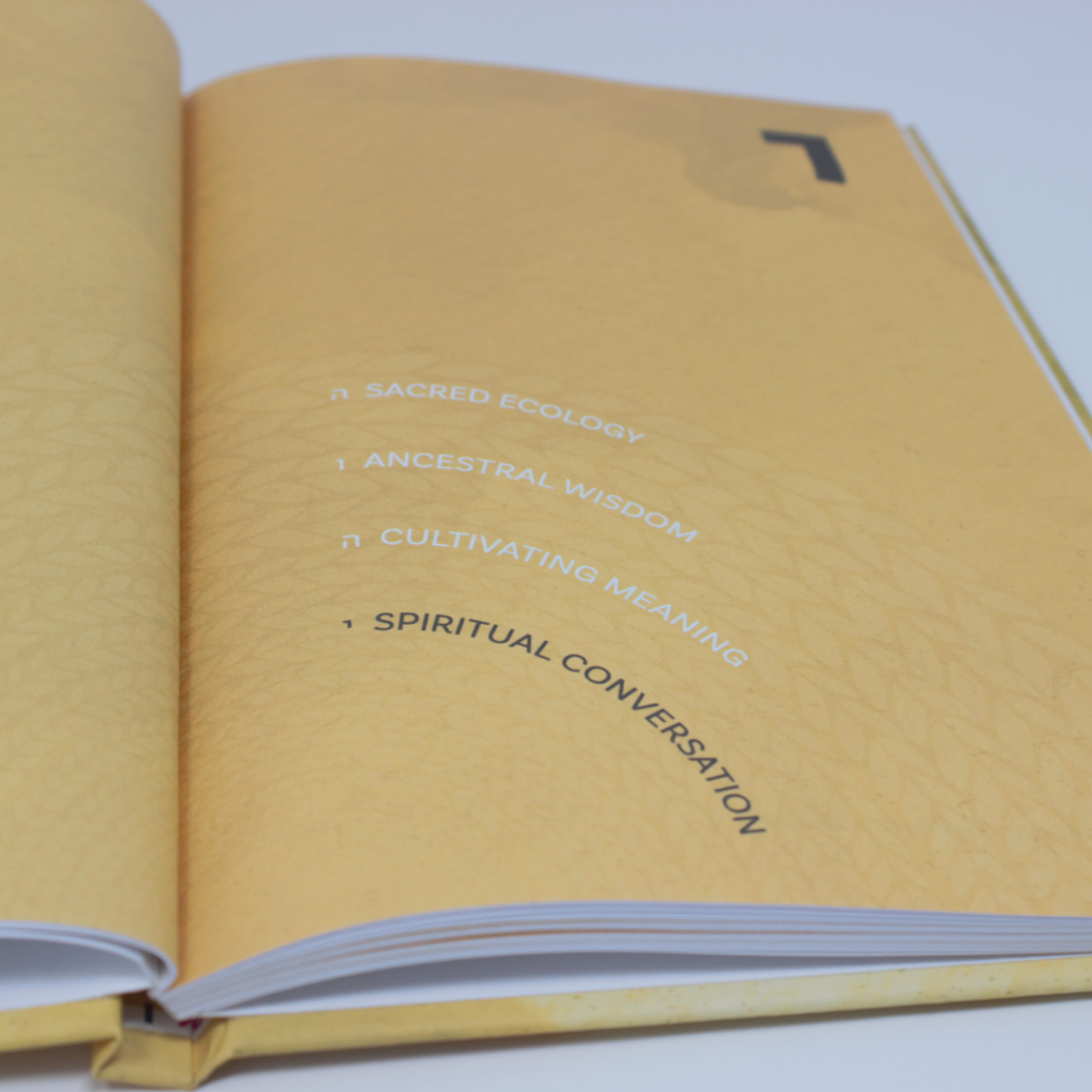 Open book with a yellow page listing themes: Sacred Ecology, Ancestral Wisdom, Cultivating Meaning, Spiritual Conversation.