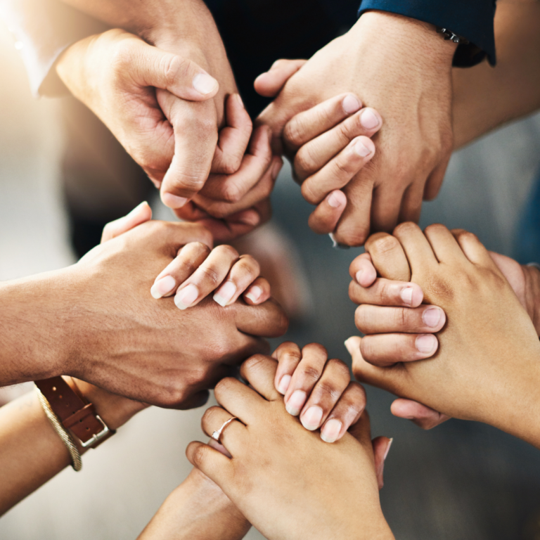 A circle of diverse hands holding each other in support and unity.