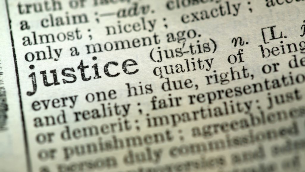 Close-up of a dictionary page showing the word justice and its definition.