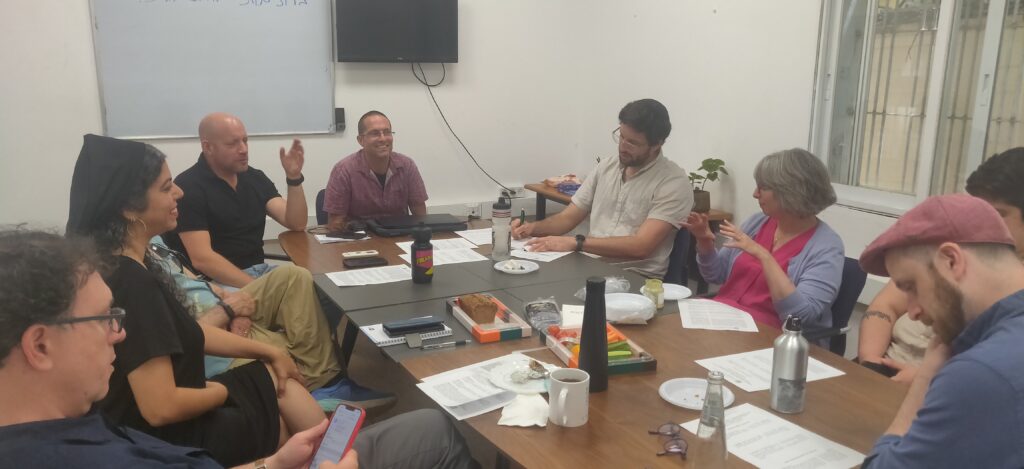 RRC faculty seated around a table in Israel.