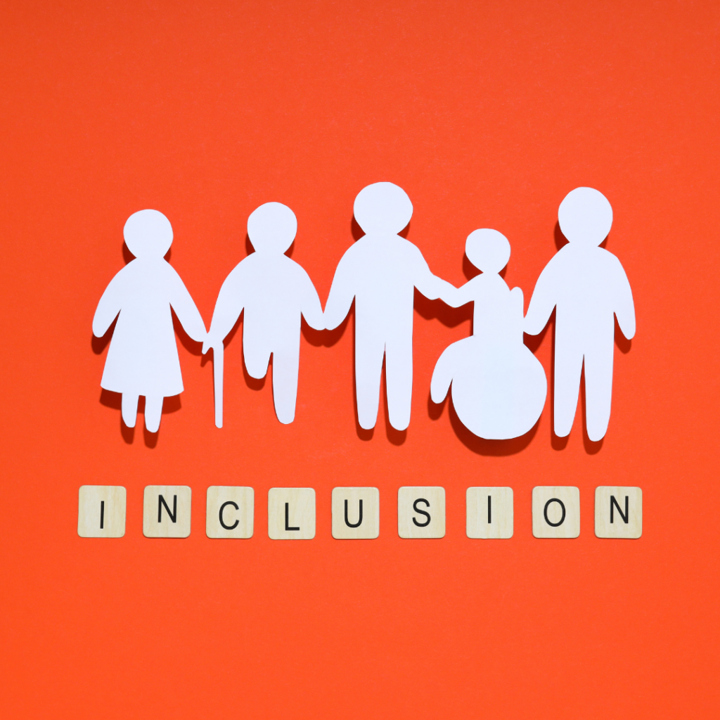 Paper cutouts of diverse figures, including one with a wheelchair, over INCLUSION spelled in tiles on an orange background.
