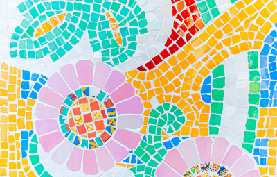 Colorful mosaic with floral and geometric patterns in pink, green, yellow, red, and blue tiles.