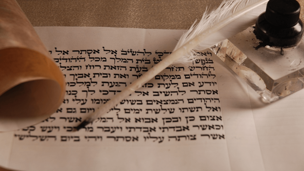 Hebrew writing on a page with a quill