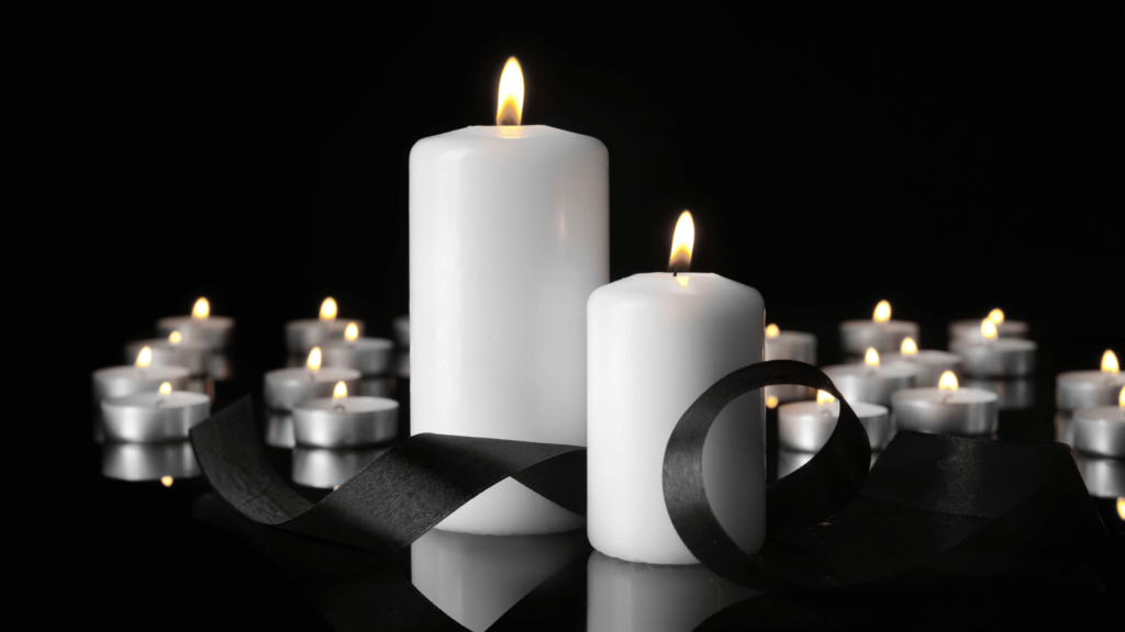 Multiple lit candles against a black background