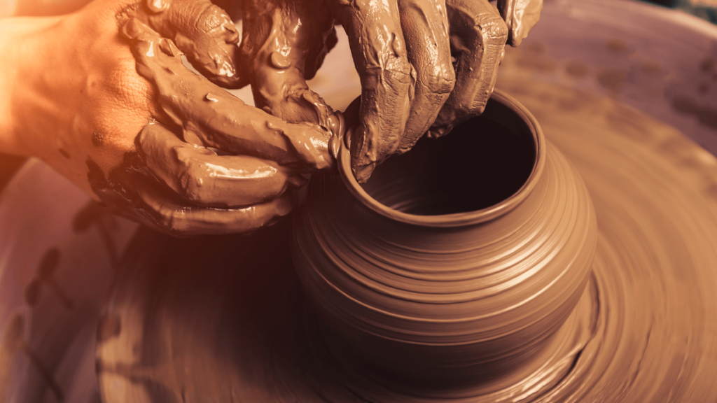 A person throwing a pot on a potter's wheel