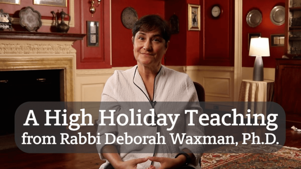 Rabbi Deborah Waxman in a room with red walls and a fireplace