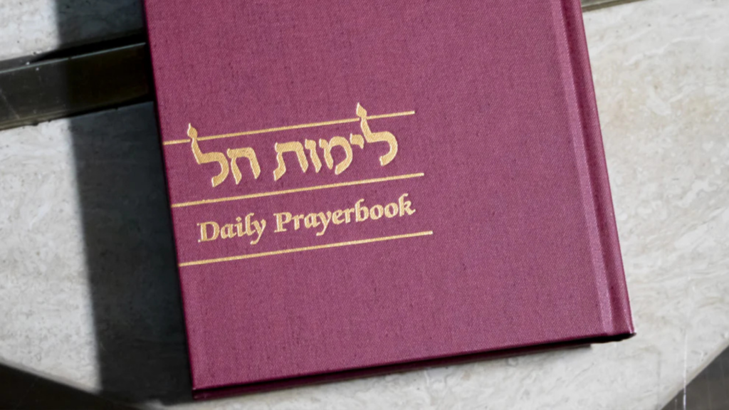 A maroon book titled Daily Prayerbook with Hebrew text on the cover.