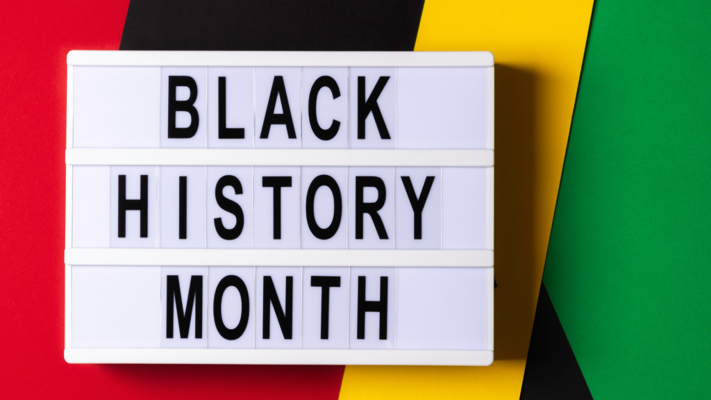 Sign displaying Black History Month against a background of red, black, yellow, and green stripes.
